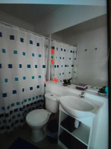 uma casa de banho com um WC branco e um lavatório. em Suitsebastian em Temuco