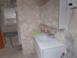 una pequeña cocina con fregadero blanco y silla en LA PROVIDENCE, en Illiat