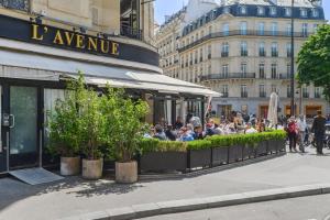 a group of people sitting outside of a restaurant at Le Luxe à la Française in Paris