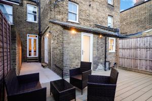 an outdoor patio with chairs and a brick building at Classy House in Maida Vale - Private Garden in London