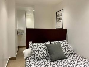 una camera da letto con un letto con un piumone bianco e nero di T5 Apartment with terrace and sun next the metro T5 a Barcellona