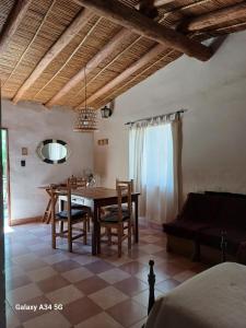 ein Wohnzimmer mit einem Tisch, Stühlen und einem Sofa in der Unterkunft Cactus y Almacen - Purmamarca in Purmamarca