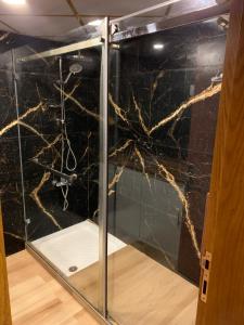 a glass shower with black marble in a room at Saleem Afandi Hotel in Nablus