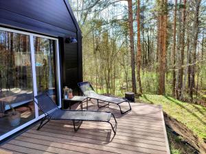 two chairs and a table on a wooden deck at Modern Sauna Cabin in Horse Ranch in Lieplaukė