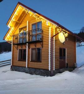 une maison en bois éclairée dans la neige dans l'établissement Zgarda, à Vorokhta