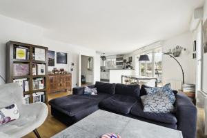 a living room with a blue couch and a table at L'Eden Urbain - Issy-les-Moulineaux in Issy-les-Moulineaux