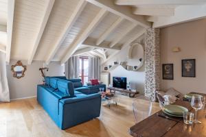 sala de estar con sofá azul y mesa en Mansarda Tra Le Risaie - Certosa di Pavia - by Host4U, en Torre del Mangano