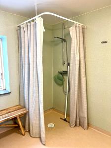 La salle de bains est pourvue d'une douche avec rideau de douche. dans l'établissement Orehus - Country side cottage with garden, à Sjöbo