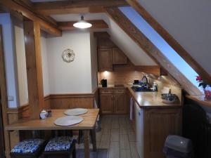 a kitchen with wooden cabinets and a table in a attic at Willa pod Lipami Jagniątków in Jelenia Góra-Jagniątków