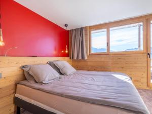 a bed in a room with a red wall at Appartement Avoriaz, 4 pièces, 8 personnes - FR-1-314-129 in Avoriaz