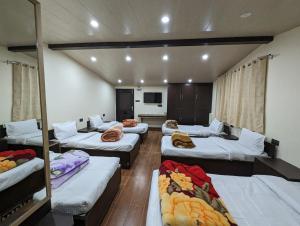 a room with several beds in a room at Summer Capital BnB in Shimla