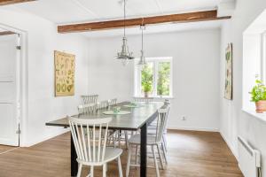comedor con paredes blancas y mesa y sillas de madera en Orehus - Country side cottage with garden en Sjöbo
