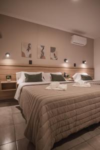 um quarto com uma cama grande e toalhas em Hotel Libertad em Villa Carlos Paz