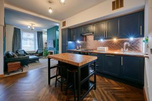 a kitchen with dark blue cabinets and a wooden island at Host & Stay - 19 Garswood in Liverpool