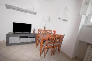 d'une salle à manger avec une table, deux chaises et une télévision. dans l'établissement Delightful Apartment Close To The Center, à Lido di Ostia