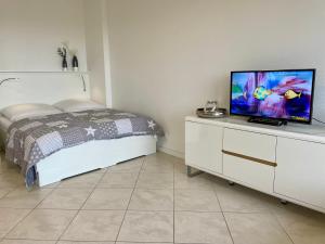 a bedroom with a bed and a tv on a dresser at Haus Kampbarg Suite 2-Meer-Blick in Kampen
