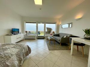 um quarto com uma cama e uma sala de estar com um sofá em Haus Kampbarg Suite 2-Meer-Blick em Kampen
