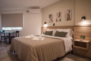 a bedroom with a large bed with two towels on it at Hotel Libertad in Villa Carlos Paz