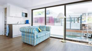 ein Wohnzimmer mit einem Sofa und einem großen Fenster in der Unterkunft Hausboot Geiseltalsee - Floating House - WELL Hausboote - Family & Friends in Braunsbedra