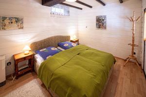 a bedroom with a bed with a green comforter at Ferienhaus Geißler Meran in Molberting