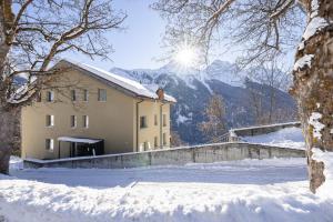 ein Gebäude im Schnee mit der Sonne im Hintergrund in der Unterkunft Saglina 22 - Nr. 1 in Sent