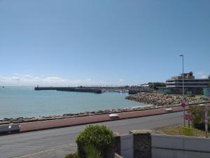 a road next to a body of water with a pier at Alizée in Granville