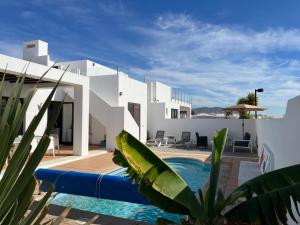 a villa with a swimming pool and white walls at Buganvilla 19 forever in Playa Blanca