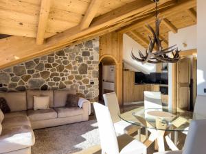 un soggiorno con tavolo in vetro e parete in pietra di Silva: The Alpine Chalet a Livigno