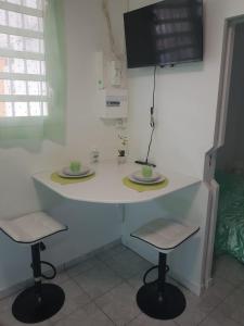 uma mesa com duas cadeiras e uma televisão na parede em MER ET SOLEIL em Port-Louis