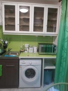 uma cozinha com uma máquina de lavar roupa e um micro-ondas em MER ET SOLEIL em Port-Louis