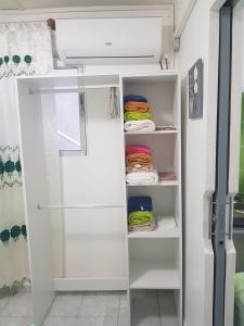 um armário com prateleiras brancas e um frigorífico em MER ET SOLEIL em Port-Louis
