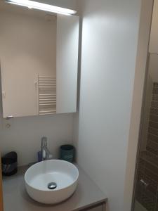 La salle de bains est pourvue d'un lavabo blanc et d'un miroir. dans l'établissement Alizée, à Granville