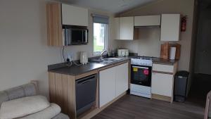 a small kitchen with a sink and a stove at Your Holidays in Scotland. in Eyemouth
