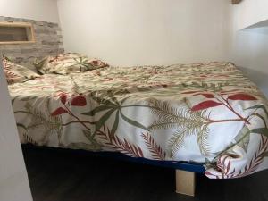 a bed with a comforter on it in a bedroom at Joli loft rénové in Payré +6 photos