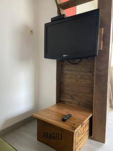 a flat screen tv on top of a box with a remote control at Joli loft rénové in Payré