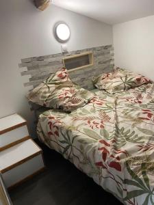 een slaapkamer met een bed en een bakstenen muur bij Joli loft rénové in Payré