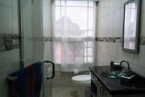 a bathroom with a sink and a toilet and a window at HK Loft Apartment Studio in La Ceiba