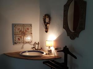 uma casa de banho com um lavatório, um candeeiro e espelhos em Casa con vista mozzafiato su Civita di Bagnoregio em Lubriano