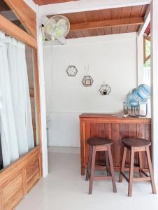 una camera con due sgabelli e una scrivania in legno di Rascal House Gili Trawangan a Gili Trawangan