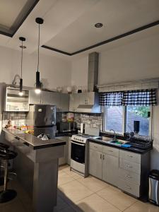 uma grande cozinha com utensílios de aço inoxidável e uma janela em HK Loft Apartment Studio em La Ceiba