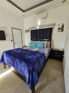 um quarto com uma cama grande e um edredão azul em HK Loft Apartment Studio em La Ceiba