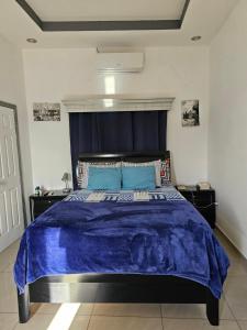 a bedroom with a large blue bed with blue sheets at HK Loft Apartment Studio in La Ceiba