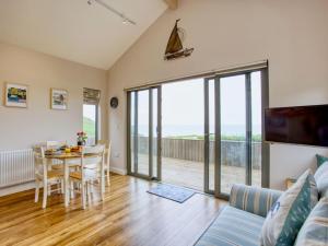 uma sala de estar com uma mesa e uma sala de jantar em Beautiful Seaside Holiday Home em West Bay