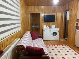 a small living room with a washer and dryer at Yildirim Aile Pansiyonu in Sultan Murat Yaylasi