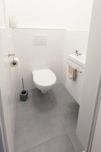 a white bathroom with a toilet and a sink at BÄRNAppartements in Barnbach