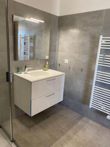 W łazience znajduje się biała umywalka i lustro. w obiekcie A Toretta, magnifique T2 4 pers avec vue mer panoramique w Ajaccio