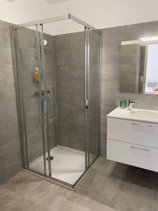 La salle de bains est pourvue d'une douche avec une porte en verre. dans l'établissement A Toretta, magnifique T2 4 pers avec vue mer panoramique, à Ajaccio