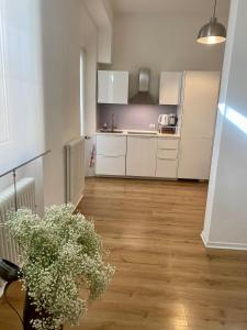 a kitchen with white cabinets and a vase of flowers at [PIAZZA GARIBALDI] ELEGANTI SUITE CON SAUNA in Udine