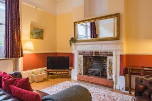 a living room with a fireplace and a television at The Old Bank House in Margate