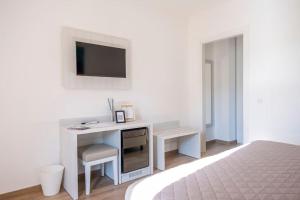a bedroom with a desk with a tv on a wall at Laurus Cilento Relax BeB in Laureana Cilento